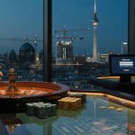 At dusk inside a sleek Berlin casino, a roulette wheel reflects the Fernsehturm while