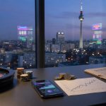 Dusk view from a Berlin office with the Fernsehturm beyond the window; on the